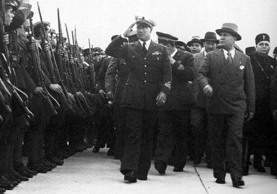 Galeazzo Ciano w mundurze pilota (salutuje) wraz z Benito Mussolinim przeprowadzają inspekcję żołnierzy wyruszających na wojnę z Abisynią. Maj 1936.